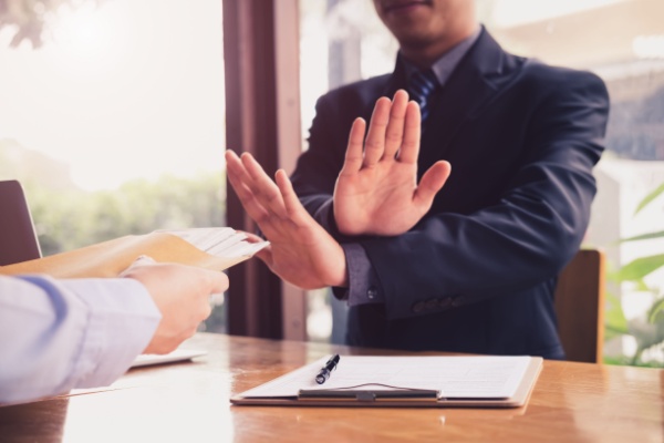 Homme faisant un geste de refus de la main à son bureau